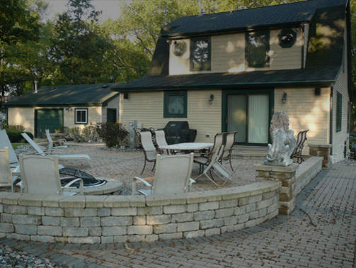 Extended summer living area with paver brick patio and large firepit in Lake Geneva